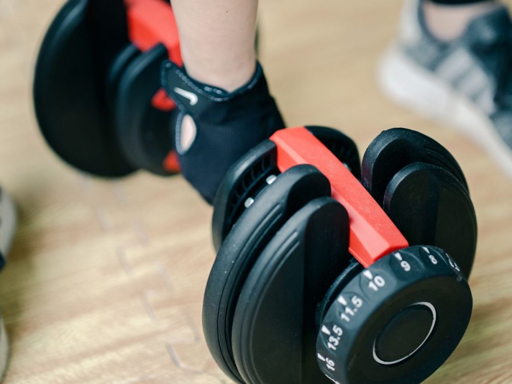 Picking up adjustable dumbbells to begin workout